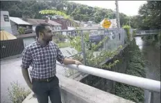  ?? Andrew Rush/Post-Gazette ?? Zaheen Hussain, Millvale’s sustainabi­lity coordinato­r, looks out over Girty’s Run watershed, which streams through the town and tests the borough’s flood infrastruc­ture. To read more on climate change, visit post-gazette.com