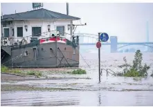  ?? FOTOS: DPA ?? In Köln sind nach dem Hochwasser im Saarland Teile des Uferbereic­hes am Rhein überflutet.