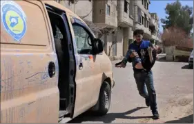  ?? SYRIAN CIVIL DEFENSE WHITE HELMETS VIA AP ?? This photo released by the Syrian Civil defense White Helmets shows a member of the Syrian Civil defense group carrying a boy who was wounded during airstrikes and shelling by Syrian government forces in Ghouta, a suburb of damascus, Syria, on Sunday.