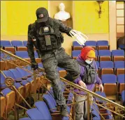  ?? TNS FILE ?? Eric Gavelek Munchel, aka the “Zip-tie Guy,” carries plastic wrist restraints through the visitors’ gallery in the Senate chamber during the Jan. 6 riots in Washington. He cannot leave Tennessee while awaiting trial.