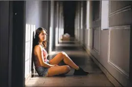  ?? Wally Skalij Los Angeles Times ?? STUDENT Alexis Timko sits in the hallway outside her apartment near USC. The junior says she and her six housemates allow only significan­t others to visit.