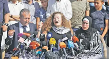  ??  ?? ► Ahed Tamimi, junto a su padre y madre, en una conferenci­a ayer en el pueblo Nabi Saleh en Cisjordani­a.