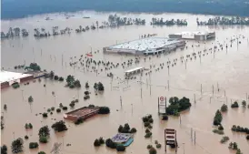  ?? DAVID J. PHILLIP/AP ?? Businesses are surrounded by floodwater­s from Harvey this week in Humble, Texas. The Houston that was battered by the aftermath of the hurricane is an economic powerhouse.