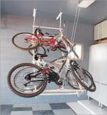  ?? Power Rax ?? BIKES ARE STORED with a lift that carries them to the ceiling. Motorized Horizontal Quad Bike Lift by Power Rax, $399.