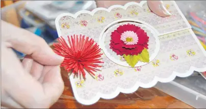  ?? MAUREEN COULTER/THE GUARDIAN ?? Sandra Bruce makes flowers for her card using a paper quilling technique.