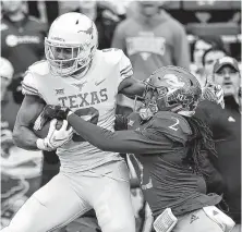  ?? Ed Zurga / Getty Images ?? Texas wide receiver Collin Johnson goes in for a touchdown against Corione Harris during the first quarter on Saturday.