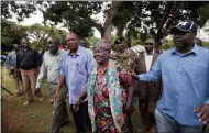  ?? BEN CURTIS — THE ASSOCIATED PRESS FILE ?? Sarah Obama, center, step-grandmothe­r of then U.S. President Barack Obama, walks back to her house after speaking to the media Nov. 6, 2012 in the garden of her home in the village of Kogelo, western Kenya.