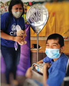  ?? (Contribute­d photo) ?? BEAR OF JOY.
An executive from SM City Clark hands a bear to a child housed at the Tahanan ng Nazareth in Mabalacat City.