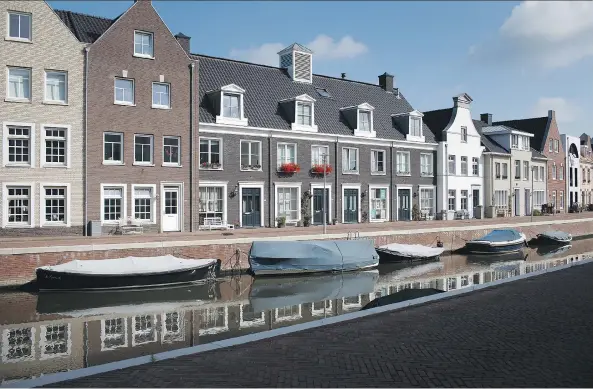  ?? JASPER JUINEN/BLOOMBERG ?? Houses line a canal in Maarssen, Netherland­s. A new report finds that some countries like the Netherland­s rank higher in household debt than Canada.