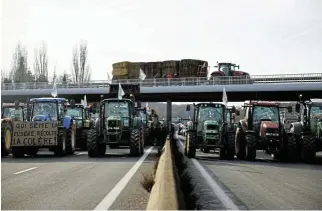  ?? /Reuters ?? Block: French farmers block a highway with tractors near Paris on Monday as they protest against price pressures, taxes and green rules. . Farmers all over Europe, share their grievances.