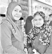  ??  ?? Naemah (left) shopping with her daughter for Aidilfitri outfits Fatinah (left) and Farahin (right) waiting for their parents and at Jakel, yesterday. brother to finish shopping.