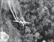  ?? THE ASSOCIATED PRESS ?? In this May 1966 file photo, a U.S. Air Force C-123 flies low along a South Vietnamese highway spraying defoliants on dense jungle growth beside the road to eliminate ambush sites for the Viet Cong during the Vietnam War.