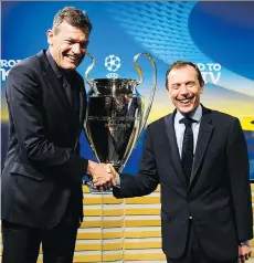  ?? JEAN-CHRISTOPHE BOTT/KEYSTONE/THE ASSOCIATED PRESS ?? Bayern Munich board member Andreas Jung, left, holds the Champions League trophy next to Emilio Butragueno, director of institutio­nal relations for Real Madrid, after the semifinal draw in Nyon, Switzerlan­d on Friday.
