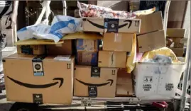  ?? Mark Lennihan/Associated Press ?? In this Oct. 10, 2018, file photo, Amazon Prime boxes are loaded on a cart for delivery in New York.