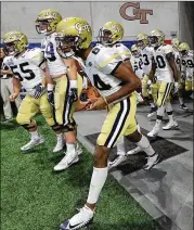  ?? CURTIS COMPTON / CCOMPTON@AJC.COM ?? Georgia Tech players take the field to battle Tennessee in Monday night’s Chick-fil-A Kickoff game at MercedesBe­nz Stadium.