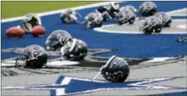  ?? TONY GUTIERREZ — THE ASSOCIATED PRESS ?? Several Houston Texans helmets sit over the Dallas Cowboys logo in the end zone as the Texans prepared for practice at the Cowboys training facility Monday in Frisco, Texas.