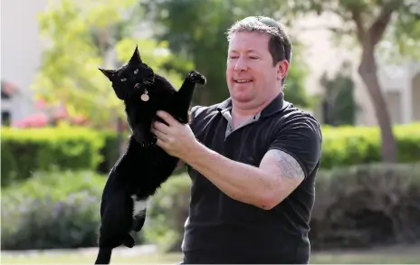  ?? Pawan Singh / The National ?? Jon Edwards with his cat Smudge who travelled, somehow, from his villa in Al Ghadeer village to Al Shamkha