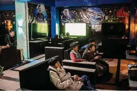  ?? ?? Teenagers lounge on couches playing at a video game den in Kabul, Afghanista­n. The Taliban have tried to remove all western influences, but some remain.