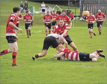  ?? 01_B38rugby03 ?? Left: An Arran player breaks through a defensive sea of red Birkmyre players.