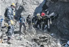  ?? YVES MALENFER/MINISTERE DE L’INTERIEUR/THE ASSOCIATED PRESS ?? French emergency workers search among debris of the Germanwing­s passenger jet near Seyne-les-Alpes, France, earlier this week.