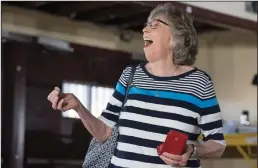  ??  ?? Donna Brown reacts as she finds the silver dollar that was replaced as her wallet is returned to her. The original silver dollar was taken and Shawn Coles donated the replacemen­t in the wallet.