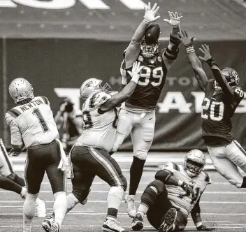  ?? Jon Shapley / Staff photograph­er ?? Texans defensive end J.J. Watt (99) leaps for one of his career-high four pass deflection­s against Patriots quarterbac­k Cam Newton on Sunday. The Texans made two sacks and allowed just 86 yards rushing.