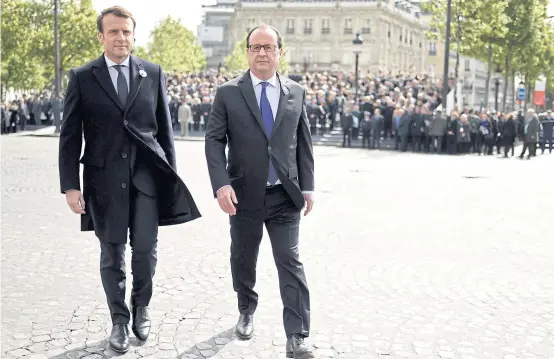  ??  ?? Outgoing French President Francois Hollande, right, and Presidente­lect Emmanuel Macron attend a ceremony to mark the end of World War II at the Tomb of the Unknown Soldier at the Arc de Triomphe in Paris, yesterday.