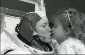  ?? COURTESY OF NASA ?? Astronaut Anna Lee Fisher kisses daughter Kristin after training for a spacewalk in 1985.