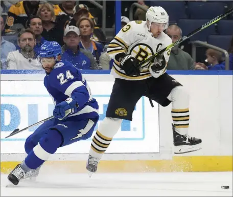  ?? CHRIS O’MEARA — THE ASSOCIATED PRESS ?? Boston Bruins left wing Brad Marchand, right, slips past a check by Tampa Bay Lightning defenseman Matt Dumba during the first period. The Bruins fell 3-1on the road.