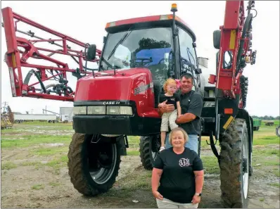  ?? PHOTOS BY CAROL ROLF/CONTRIBUTI­NG PHOTOGRAPH­ER ?? Johnny Wayne Taylor recently bought this self-propelled sprayer for use on J&J Taylor Farms. Shown with him are his wife, Jennifer Taylor, and their 3-year-old granddaugh­ter, Lanie Paige McElyea.