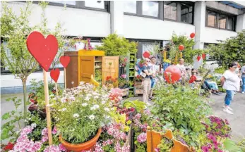  ??  ?? Auch den Platz vor dem Rathaus schmücken viele Herzen und bunte Blumen.