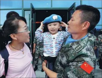  ?? YUAN XIAOQIANG / FOR CHINA DAILY ?? Wang Ruichen tries on the blue beret of his father, Wang Changqing, who is a member of a Chinese engineerin­g unit heading to Wau, South Sudan, for a United Nations peacekeepi­ng mission, in Mengjin, Henan province. The soldiers said goodbye to their families on Wednesday. The 268 members of the unit will be responsibl­e for improving local infrastruc­ture, including water, power and heating facilities, and for providing engineerin­g support for other UN peacekeepi­ng troops.