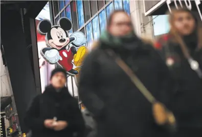  ?? Drew Angerer / Getty Images ?? A Mickey Mouse image hangs outside the Times Square Disney Store. The Disney stable of characters will grow.