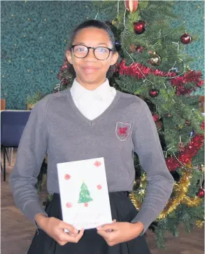  ??  ?? A St Mark’s School pupil with one of the Christmas cards which were made for residents at the Lambrook Court retirement developmen­t in Bath