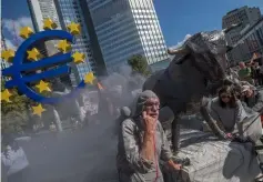  ??  ?? Activists of campaignin­g movement ‘attac’ are dressed as ‘slaves of the Financial system’ as they rally in front of the old buildings of the European Central Bank ECB in Frankfurt am Main on behalf of the 10th anniversar­y of the collapse of US investment bank Lehman Brothers which unleashed a global economic crisis. — AFP photo