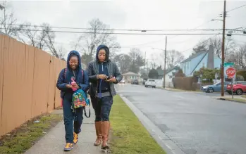  ?? KIRSTEN LUCE/THE NEWYORKTIM­ES ?? J. Marie Jones walks her daughter, Kaiya, to school Jan. 31 in Roosevelt, NewYork.