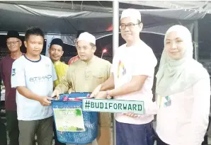  ??  ?? JAMAWI (tiga kanan) bersama Wakil Sebaran Budi Ave Haryati (kanan) menyampaik­an sumbangan bakul makanan kepada salah seorang saudara baru semasa ziarah di kampong Kuala Tomani Tenom.