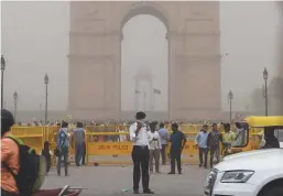  ??  ?? An Indian traffic policeman covering his face as he stands on duty during a powerful dust storm in New Delhi on Wednesday.