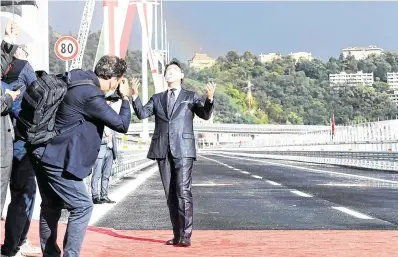  ?? GENOA PHOTO: FLAVIO LO SCALZO/ REUTERS ?? Luca Bruno, Antonio Callani and Frances D’Emilio
Inaugurati­on: Italian PM Giuseppe Conte on the Genoa bridge yesterday. Below, the remainder of the old bridge was removed last year.