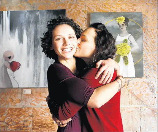  ?? SUZANNE TENNANT/POST-TRIBUNE PHOTOS ?? Nadjezda Lof, 23, kisses her sister Leanna Hall, 26, at FLUID Coffee Bar in Valparaiso. The two found one another after being placed in a Ukrainian orphanage and ending up in different adoptive homes.