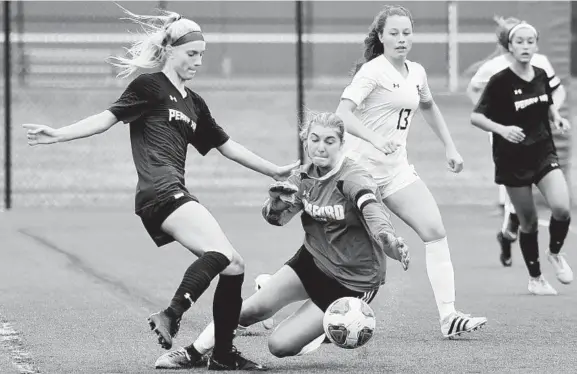  ?? KIM HAIRSTON/BALTIMORE SUN ?? Perry Hall forward Erin Marciszews­ki is prevented from getting a shot off in the first half by Harford Tech goalkeeper Raegan Salamone at the Bobcat Cup at Bel Air High School.