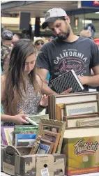  ??  ?? Bargain bin . . . Kimberly Jackson and husband Supreet Singh browse through books on sale.