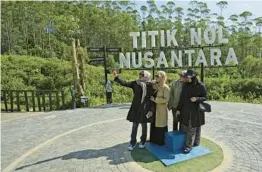  ?? ACHMAD IBRAHIM/AP ?? Tourists take a selfie at the site of Indonesia’s future capital city, under constructi­on in Penajam Paser Utara, East Kalimantan, on the island of Borneo.