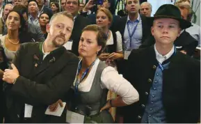  ??  ?? Grim CSU supporters are seen after the first exit polls were announced on public television at the Bavarian regional government building in Munich.