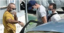  ??  ?? Maguire, in a blue cap, escorted by officers to the police station at Syros; left, on a night out in Mykonos this week with celebrity pals