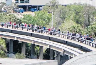  ?? KEVIN SPEAR/STAFF ?? Thousands of travelers — like these who opted to walk — were delayed Wednesday when a newly installed tram broke down at Orlando Internatio­nal Airport. Many passengers said they missed their flights.