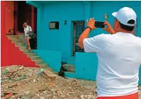  ??  ?? Jose Vazquez (right) takes a photo of his wife Ana Soto in the neighborho­od of La Perla.