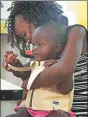  ?? ISAAC KASAMANI / AFP ?? Engineer Olivia Koburongo fits a child with the “MamaOpe” kit at the Makerere University of Public Health in Kampala.