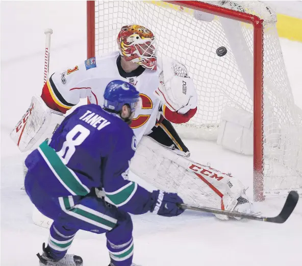  ?? — THE CANADIAN PRESS FILES ?? Canucks defenceman Christophe­r Tanev scores the game-winning goal against Calgary Flames goalie Brian Elliott during overtime in Vancouver on Saturday.