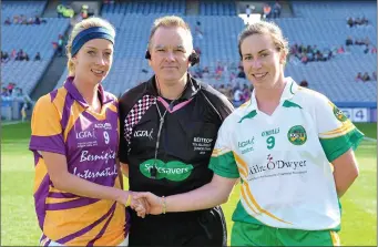 ??  ?? Wexford captain Kellie Kearney with her Offaly counterpar­t, Siobhán Flannery, and referee Michael John O’Keeffe from Cork before the TG4 All-Ireland Junior championsh­ip final of 2013.
